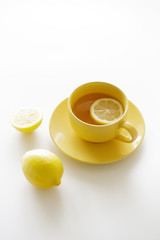 Obraz na płótnie Canvas cup of tea with fresh yellow lemons on white background