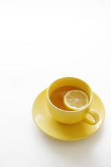 cup of tea with fresh yellow lemons on white background