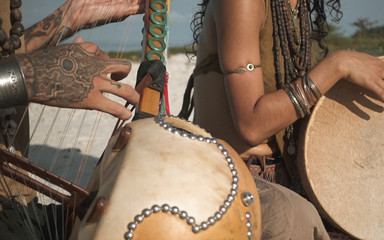 Close up of ethnic musicians playing on instruments sittar drum
