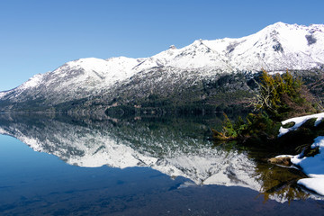Snowy mountain reflected in Lake Guillelmo during winter in Bariloche, Argentina