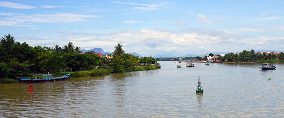 Boat traffic on the Thu Bon River in historic Hoi An, Vietnam