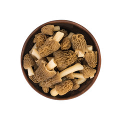 Clay bowl with fresh morels isolated on a white background.