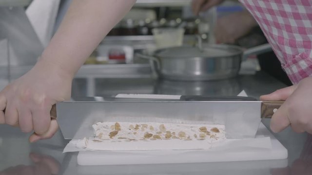 Slicing a piece of a torrone