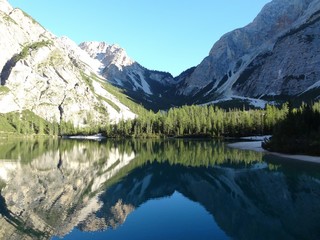 Reflection Of Snowcapped Mountains And Clear Sky On Calm Lake