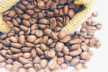 Coffee beans in a sack bag on white background