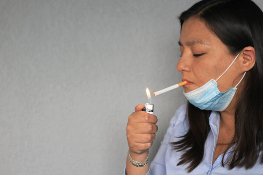 Mujer adulto con cubrebocas fumando