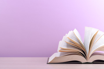 The book is open, lying on the table, sheets fanned out on a pink background.