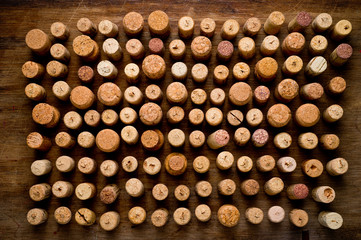 Wine corks of different sizes, standing upright on an old wooden surface. Background for liquor.