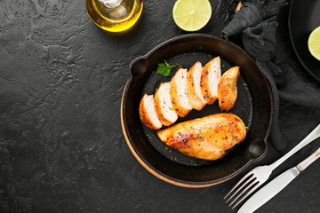 Grilled chicken breast. Sliced chicken fillet with lime served in iron pan.
