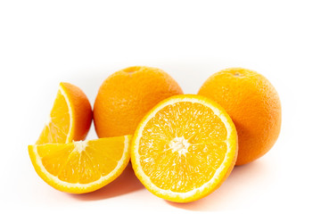 Three oranges on a white background one cut into three parts (close-up)