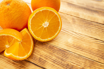 two whole and sliced orange on a wooden background (close-up)