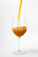 fresh orange juice is poured into a glass on a white background