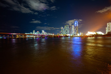Miami Skyline Panorama after sunset. Miami city skyline panorama at dusk with urban skyscrapers and bridge over sea with reflection. Miami Florida.
