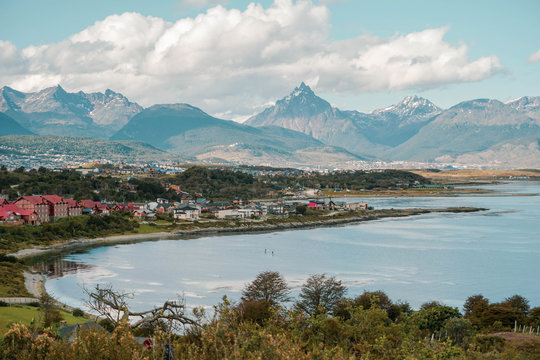 A rare view of a small city at the end of the world. Panoramic outdoor photo of a forest with a city and mountains during summer in Patagonia Argentina. 
Travelling, tourism and vacation concept.
