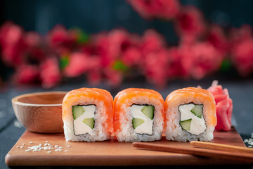 Set Philadelphia sushi roll with Sakura on a wooden Board close-Up, selective focus