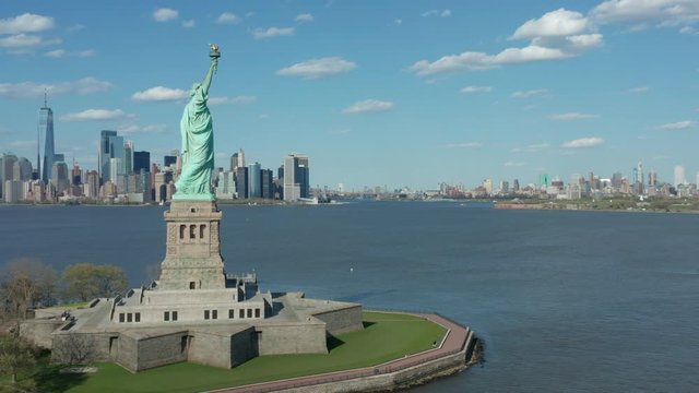 flying counter clock around Statue of Liberty w NYC in bkrd