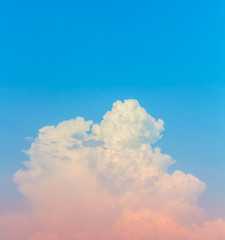 Fototapeta na wymiar vertical clouds with pink light on blue sky