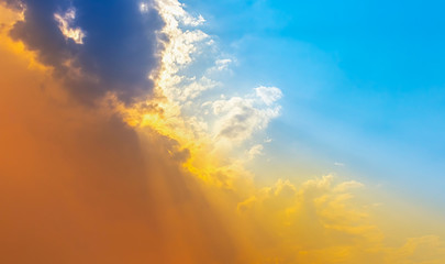 Naklejka na ściany i meble orange light in bright blue sky with soft clouds