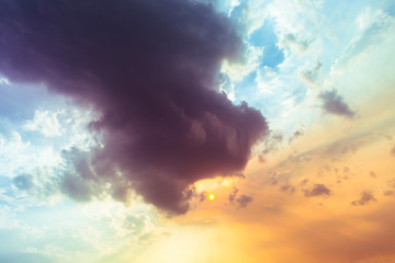 Obraz premium Dark purple Devil Clouds are swallowing the orange sun, in evening sky