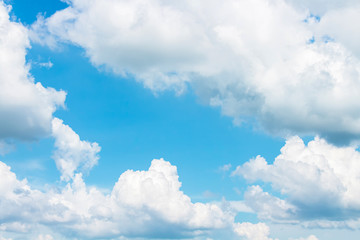 Bright fluffy clouds in light blue sky