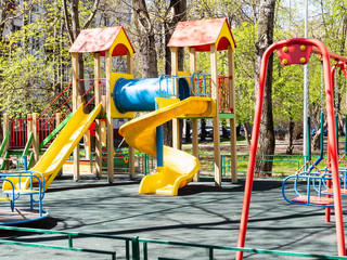 spring in city - empty children's playground in urban yard on sunny day