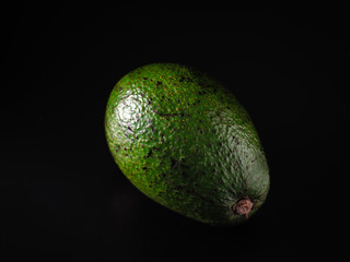 avocado fruit lies on a black background