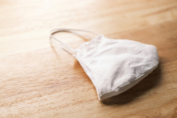 homemade white cloth masks for protection against coronavirus (COVID-19) on wooden table medium shot
