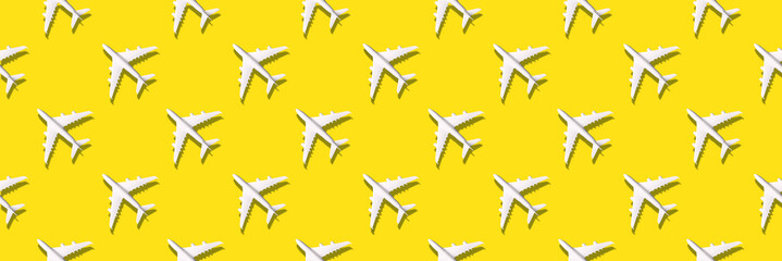 Creative banner of white planes on yellow background. Travel, vacation concept. Travel, vacation ban. Flights cancelled and resumed again. Top view. Flat lay. Minimal style design. Summer pattern.
