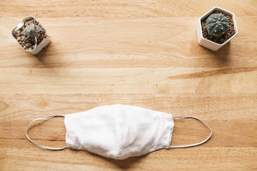 homemade white cloth masks for protection against coronavirus (COVID-19) on wooden table mediumshot