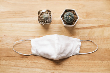 homemade white cloth masks for protection against coronavirus (COVID-19) on wooden table mediumshot