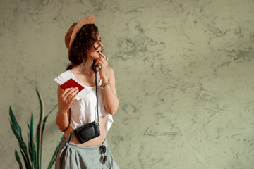Obraz premium A young girl in a white t-shirt holds a passport with air tickets in her hand
