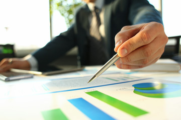 Hand of businessman in suit filling and signing with