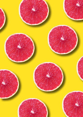 Grapefruit pattern on yellow background. Top view. Creative design, minimal flat lay concept. Summer time. Tropical travel, exotic fruit. Vegan and vegetarian food