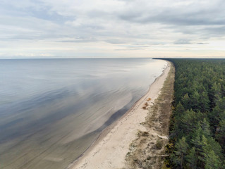 Fototapeta na wymiar Aerial view on empty Jurmala beach, Cloudy sky, Green forest, nobody. Latvia.