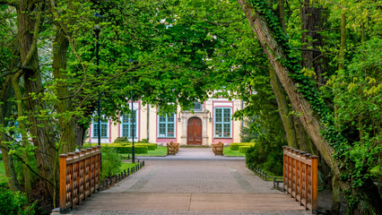 Abbots Palace in the rococo style and located in Oliwa Park in spring scenery with bridge and gree leaves.