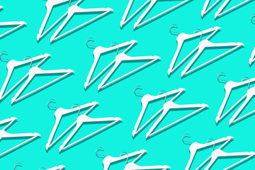 Top view of white clothes hangers on blue background with copy space. Flat lay. Minimalism style and decluttering. Creative layout. Fashion, store sale, shopping concept. Banner for feminine blog
