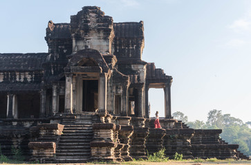 Fototapeta premium Girl walking on ruins of an old and ancient temple. 