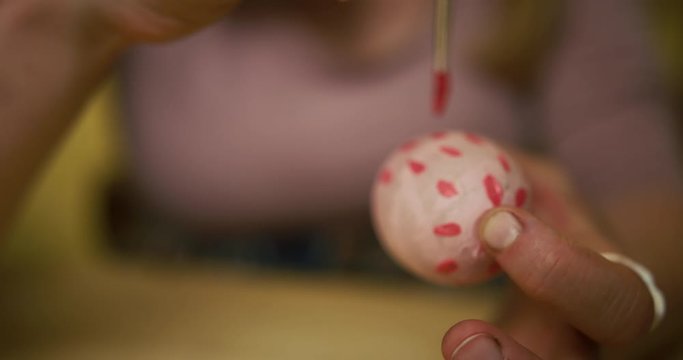 Close up on woman decorating easter egg