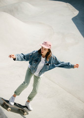 Young woman doing skateboarding trick outdoor
