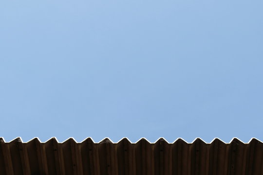 雲一つない澄んだ青空を背景とした波の形の屋根を下の位置に配置したイメージや背景に使える写真
