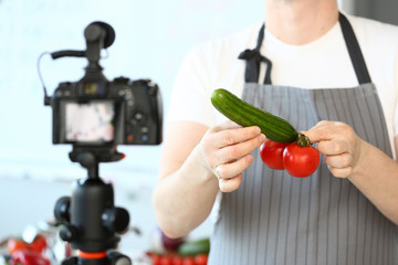 Male hand vlogger hold cucumber and