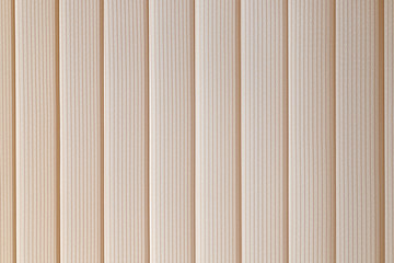 a fragment of blinds made of beige fabric from vertical slats close up