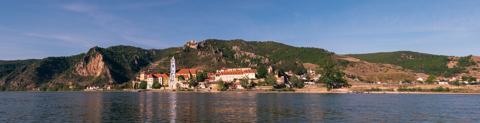 Fototapeta na wymiar Duernstein Cityscape Panorama in the Wachau Valley, with River Danube, Baroque Blue and White Tower of the Abbey Church and Kuenringer Castle on a Spring Evening