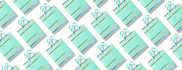 Top view of turquoise paper shopping bag pattern on trendy pink background. Copy space. Creative design for packaging. Gift concept. Woman's day. Valentine's day. Ready for birthday party.