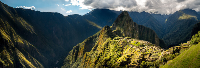 majestic wide angle panorama of machu micchu ruins with no people. valley of machu picchu with cloudscape in background. panoramic postcard photography. stunning cultural world wonder in latin america - obrazy, fototapety, plakaty