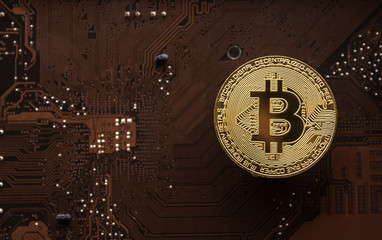 Gold bitcoin on computer mainboard with trading graph, Mining and trade bitcoin concept. 