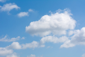 White puffy summer clouds with a bright blue sky as a backdrop