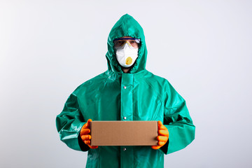 Person in whole-body garment bringing parcel during the pandemic