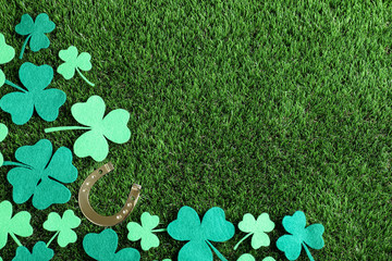 Flat lay composition with clover leaves on green grass, space for text. St. Patrick's Day...