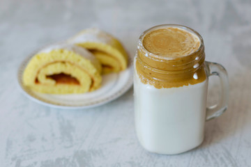 dalgona coffee and homemade biscuit on a light marble background